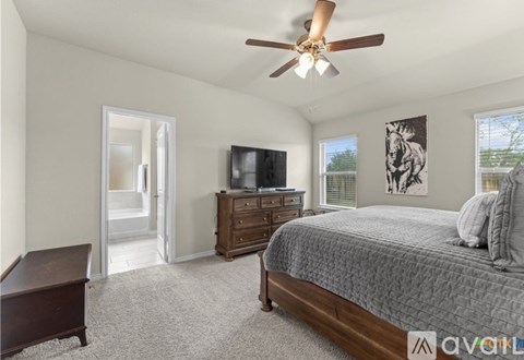 A bedroom with a bed, dresser, and television.