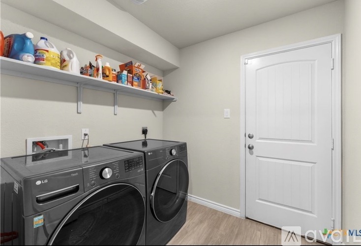 A laundry room with a washer and dryer and a white door.