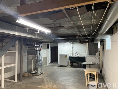 A large, empty industrial space with a table and stool in the middle.