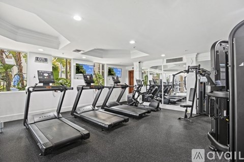 A gym with treadmills, elliptical machines, and other exercise equipment.
