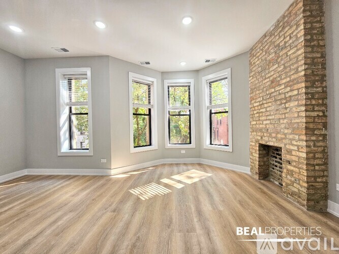 A room with a brick fireplace and wooden floors.