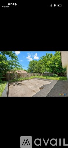 A backyard with a wooden deck and a fence.