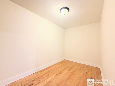 A room with wooden flooring and a light on the ceiling.
