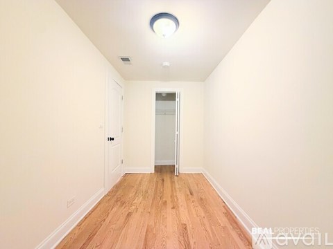 A room with wooden flooring and a white door.