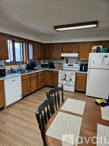 A kitchen with wooden cabinets and a white fridge.