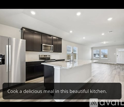 A modern kitchen with a refrigerator, microwave, oven, and a countertop.