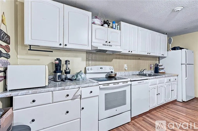 A kitchen with white cabinets and appliances.