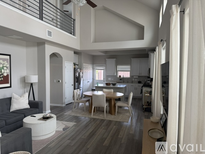 A modern living room with a grey couch and a round coffee table.