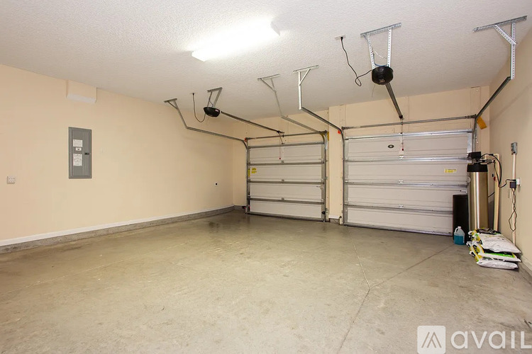 A spacious garage with a white ceiling and a closed white door.