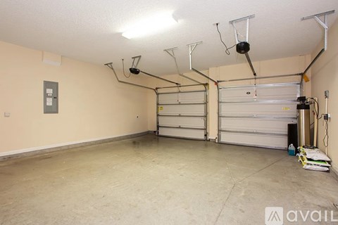 A spacious garage with a white ceiling and a closed white door.