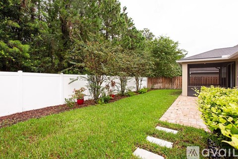 A white fence and a small building are visible in the image.