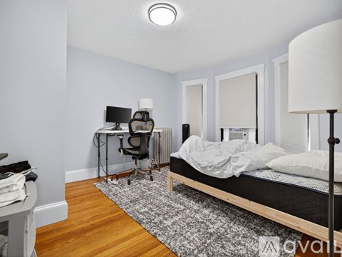 A bedroom with a bed, desk, and chair.