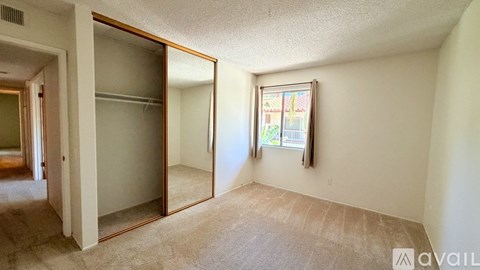 A room with a large mirror on the wall and a window with a view of a building outside.