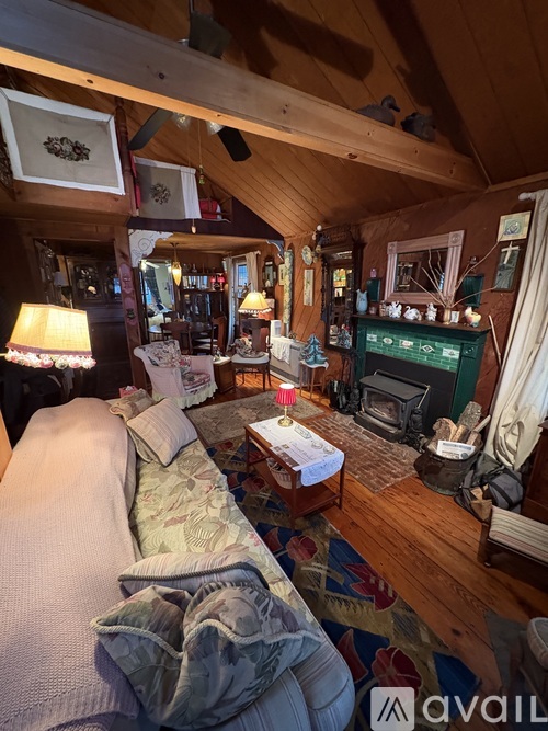 A cozy living room with a couch, a fireplace, and a rug.