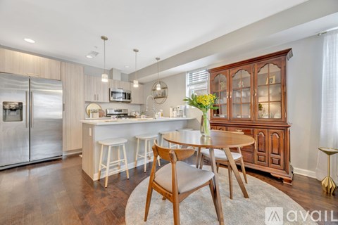 A kitchen with a wooden table and chairs.