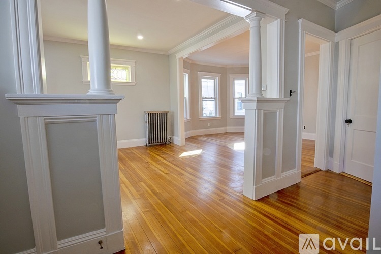 A room with wooden floors and white columns.