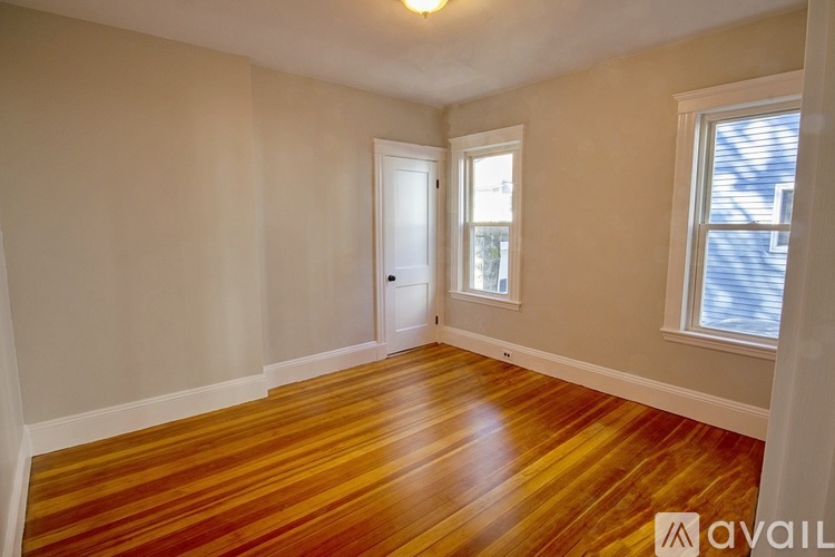 A room with wooden floors and a window with blinds.