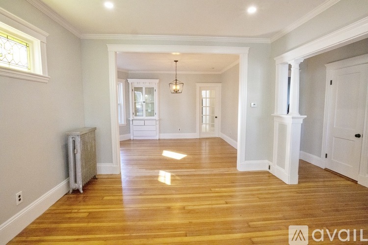 A spacious room with wooden floors and white walls.