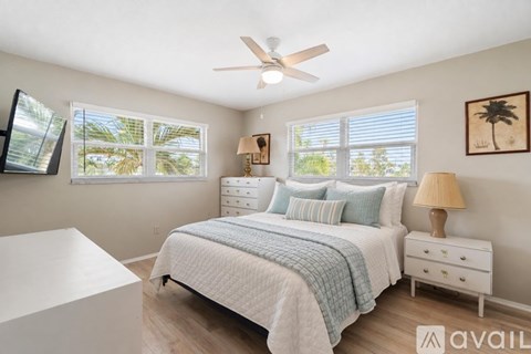 A bedroom with a bed, nightstand, and a ceiling fan.