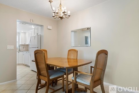 A dining room with a wooden table and chairs.