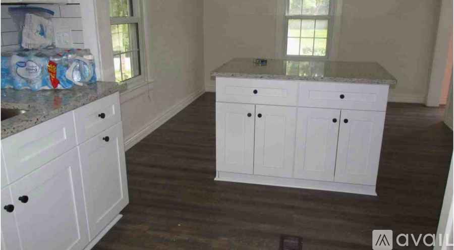 A kitchen with white cabinets and a granite countertop.