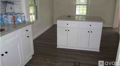 A kitchen with white cabinets and a granite countertop.