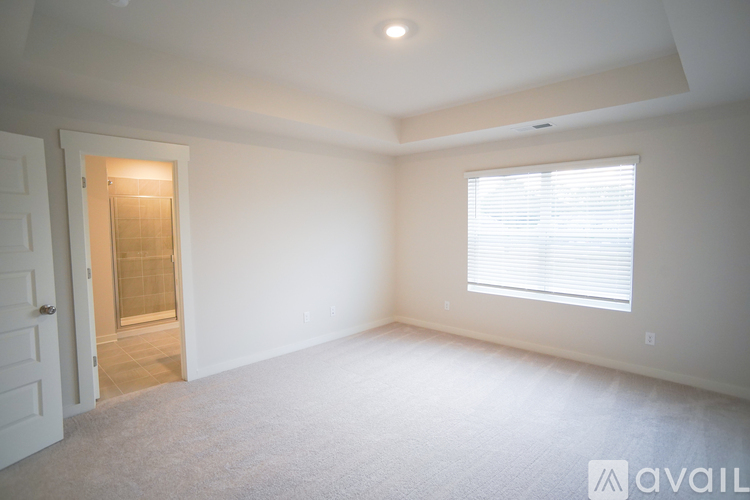 A room with a door and a window with blinds.