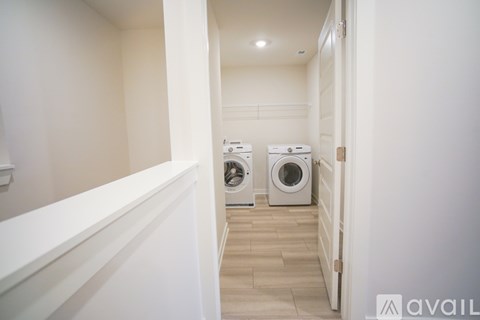 A hallway with two washing machines on the right side.