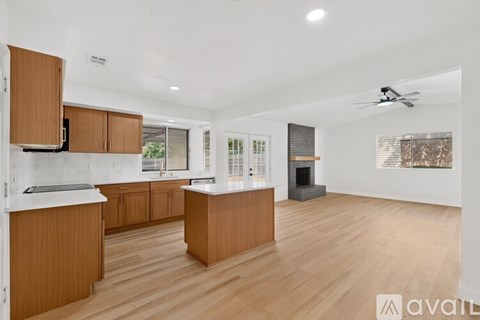 A spacious kitchen with wooden cabinets and a large island.
