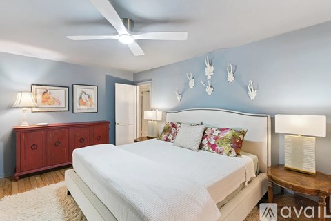A bedroom with a bed, nightstand, and a ceiling fan.