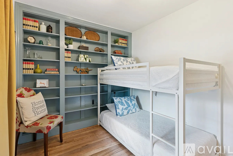 A cozy bedroom with a bunk bed and a chair with a cushion that says Home Sweet Home.