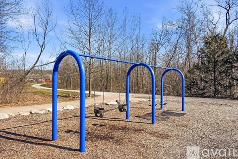 A playground swing set with a blue frame and two swings.