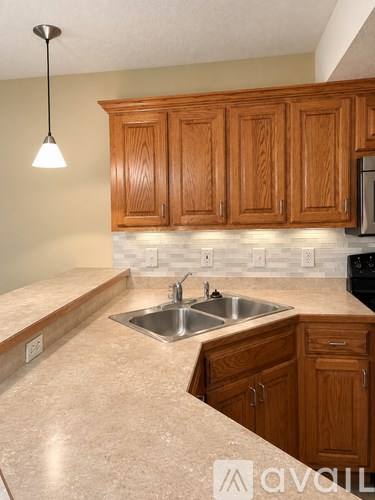 A kitchen with wooden cabinets and a granite countertop.