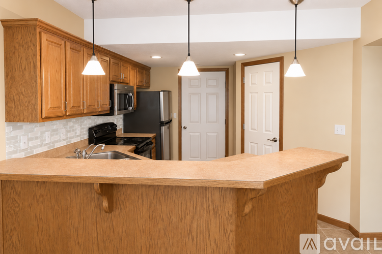 A kitchen with wooden cabinets and a black refrigerator.