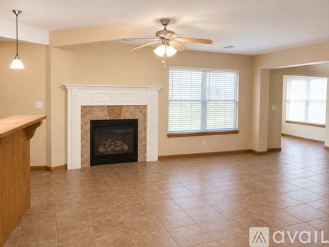 A living room with a fireplace and a ceiling fan.