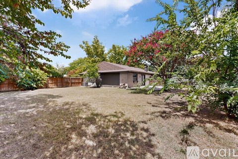 A house is surrounded by greenery and trees.