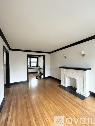 A room with a fireplace and wood flooring.
