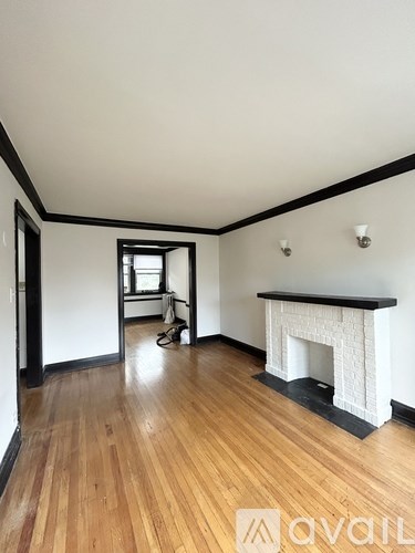 A room with a fireplace and wood flooring.