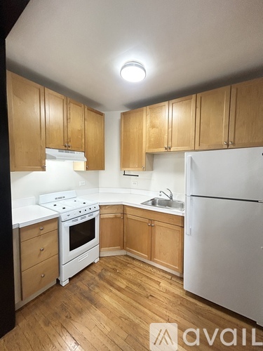 A kitchen with wooden cabinets and white appliances.