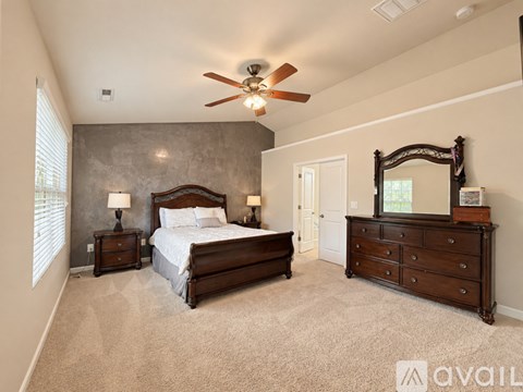 A bedroom with a large bed, a dresser, and a mirror.