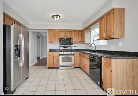 A kitchen with wooden cabinets and black countertops.