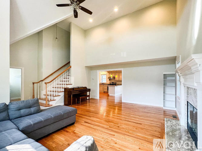A living room with a grey couch and a fireplace.