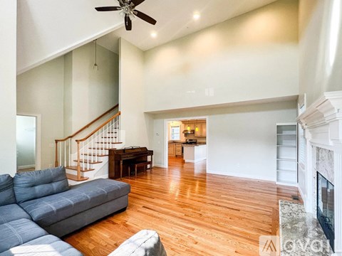 A living room with a grey couch and a fireplace.