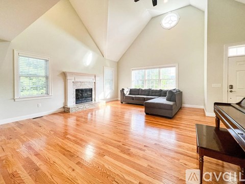 A living room with wood flooring and a fireplace.