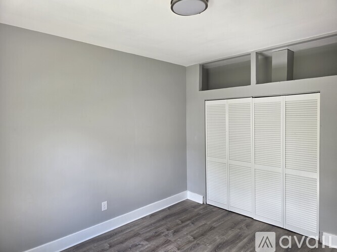 A room with a grey wall and a white door.