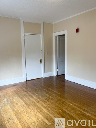 A room with wooden floors and two white doors.