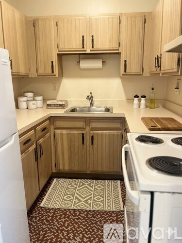 A kitchen with wooden cabinets and a white fridge.