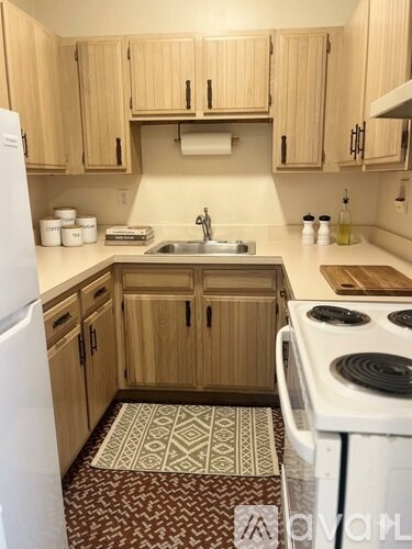 A kitchen with wooden cabinets and a white fridge.