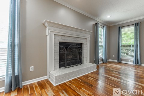 A living room with a fireplace and wood flooring.