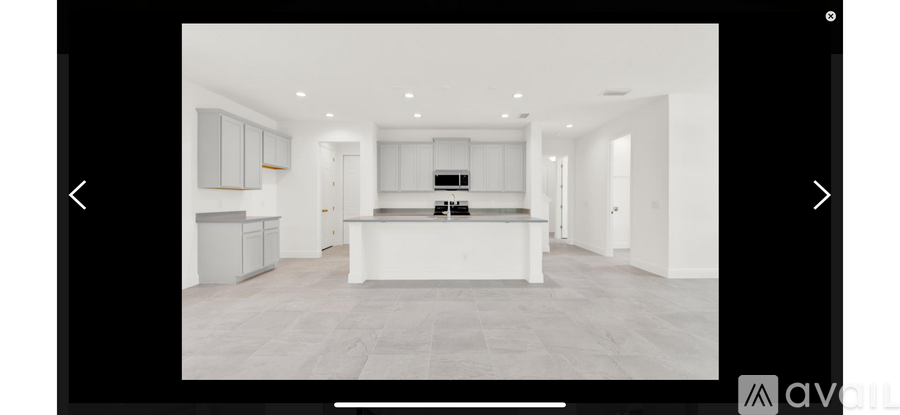 A modern kitchen with a central island and a large open space.